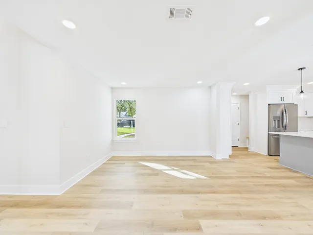 an empty room with a fireplace and wooden floor