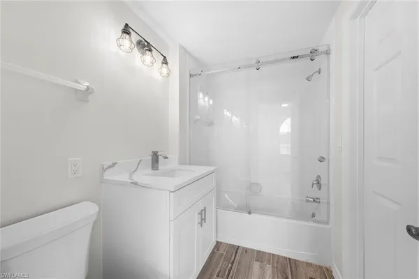 a bathroom with a bathtub shower sink vanity and toilet