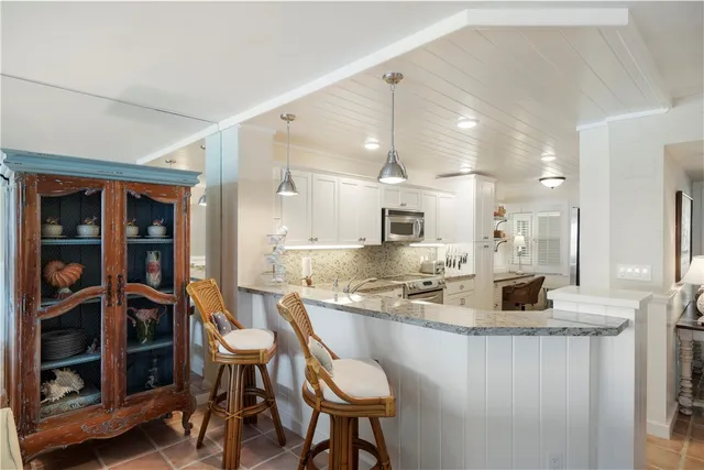 a kitchen with stainless steel appliances granite countertop a refrigerator a sink a stove and oven