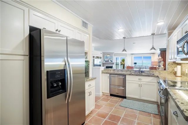 a kitchen with a counter top space a sink stainless steel appliances and cabinets
