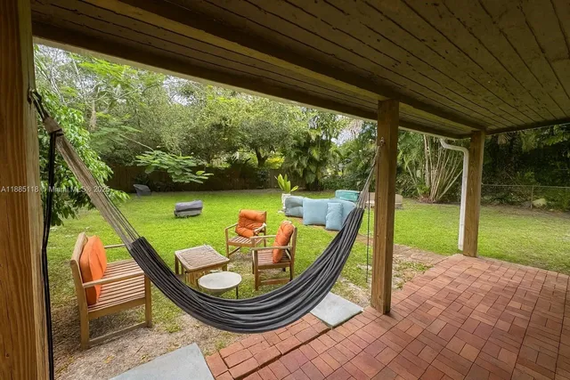 a view of a porch with furniture and a yard
