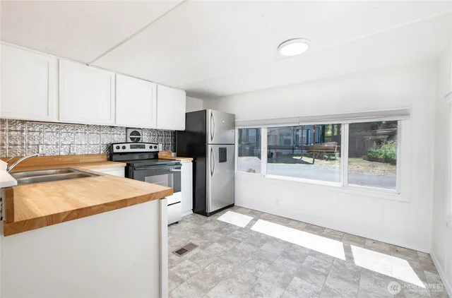 a kitchen filled with stainless steel appliances granite countertop a refrigerator a sink a stove top oven a counter space and cabinets