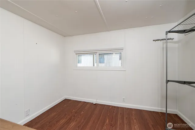 a view of a room with wooden floor and a window