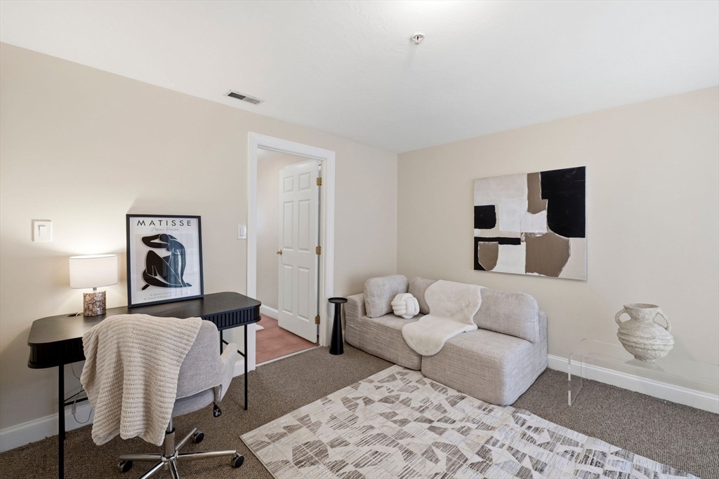 52 Packards Lane, Unit 4 Quincy, MA 02169 - Photo 24 of 40 a living room with furniture and a painting on the wall