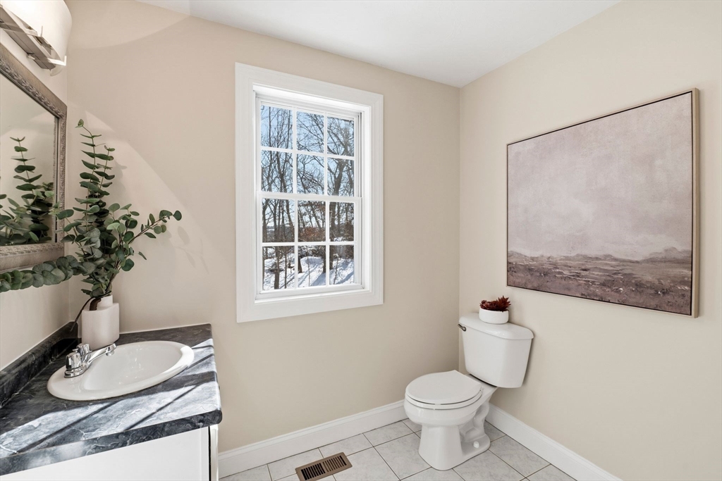 52 Packards Lane, Unit 4 Quincy, MA 02169 - Photo 28 of 40 a bathroom with a granite countertop sink and a toilet