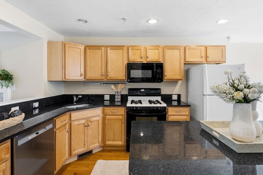 52 Packards Lane, Unit 4 Quincy, MA 02169 - Photo 8 of 40 a kitchen with stainless steel appliances a stove a sink a microwave a refrigerator and cabinets