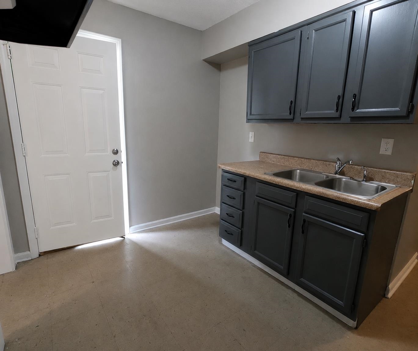 1672 Clancy Street Memphis, TN 38106 - Photo 3 of 7 Kitchenette featuring gray cabinetry, dual stainless steel sinks, laminate countertops, and neutral wall paint