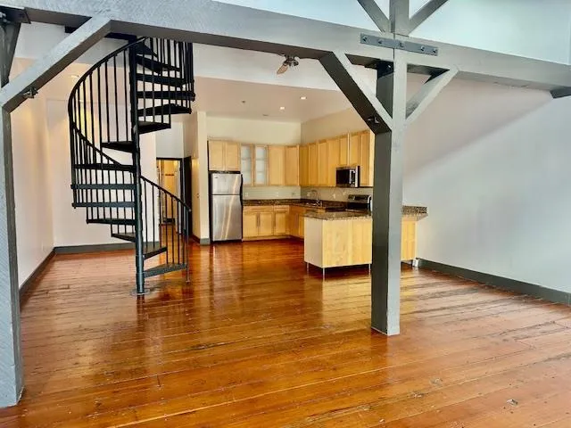 a view of entryway and hall with wooden floor