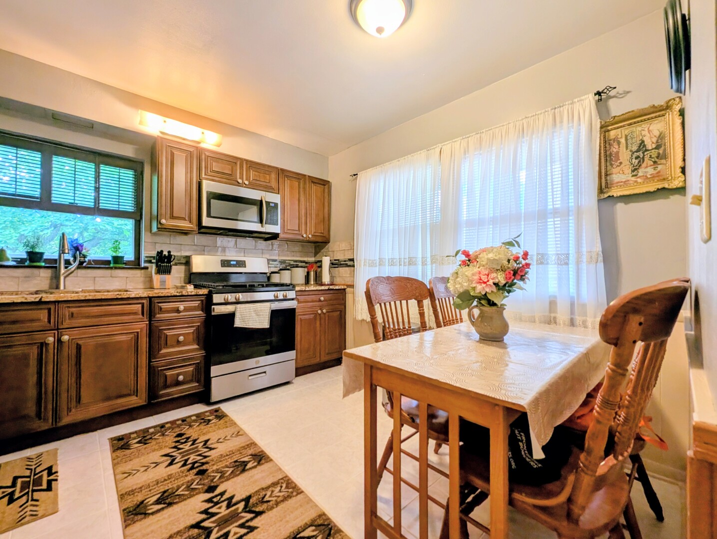 4229 North Keystone Avenue, Unit 3H Chicago, IL 60641 - Photo 10 of 22 a kitchen with stainless steel appliances granite countertop a stove top oven a sink a dining table and chairs