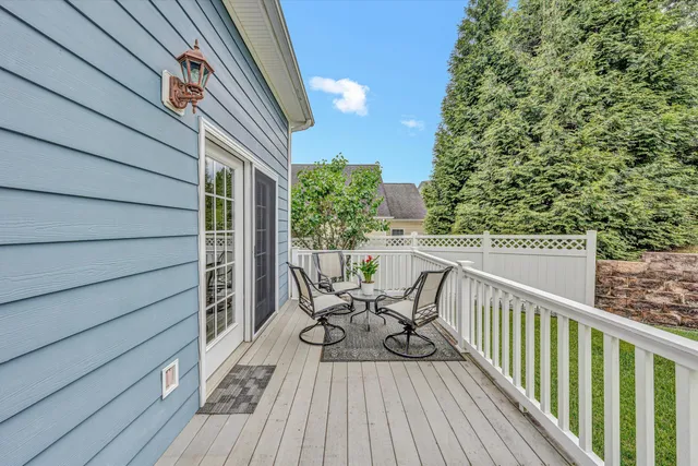 a backyard of a house with wooden deck and barbeque oven