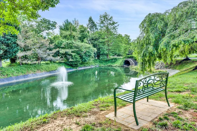 a view of a house with a big yard and large trees
