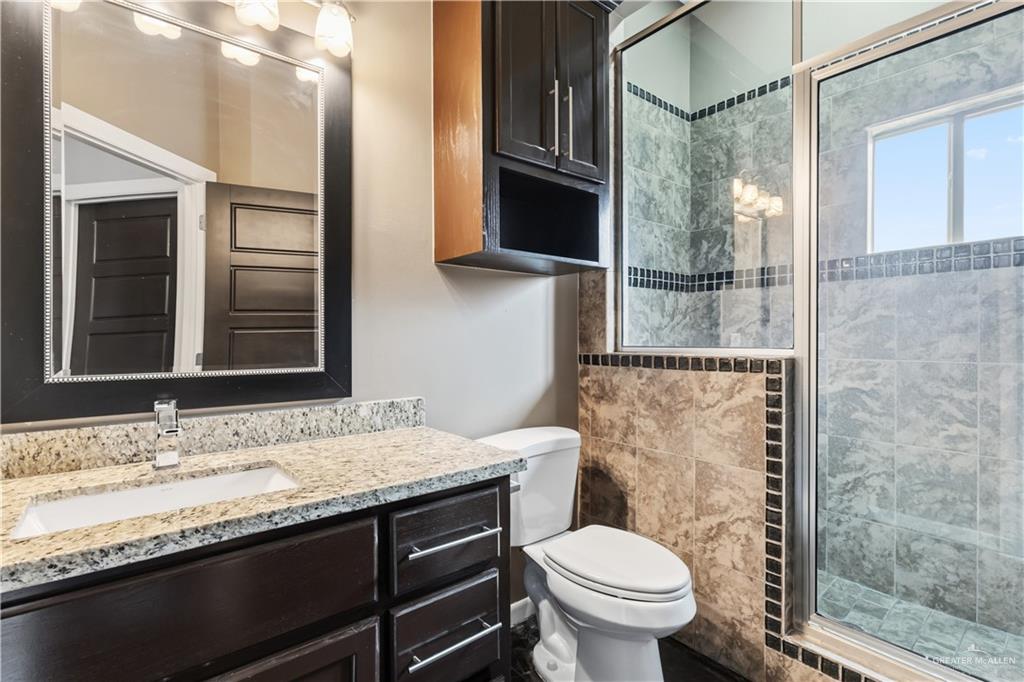 1342 Patsy Cline Drive Edinburg, TX 78541 - Photo 16 of 18 a bathroom with a granite countertop toilet sink and mirror