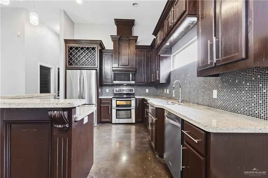 1342 Patsy Cline Drive Edinburg, TX 78541 - Photo 3 of 18 a kitchen with stainless steel appliances granite countertop a sink stove and refrigerator