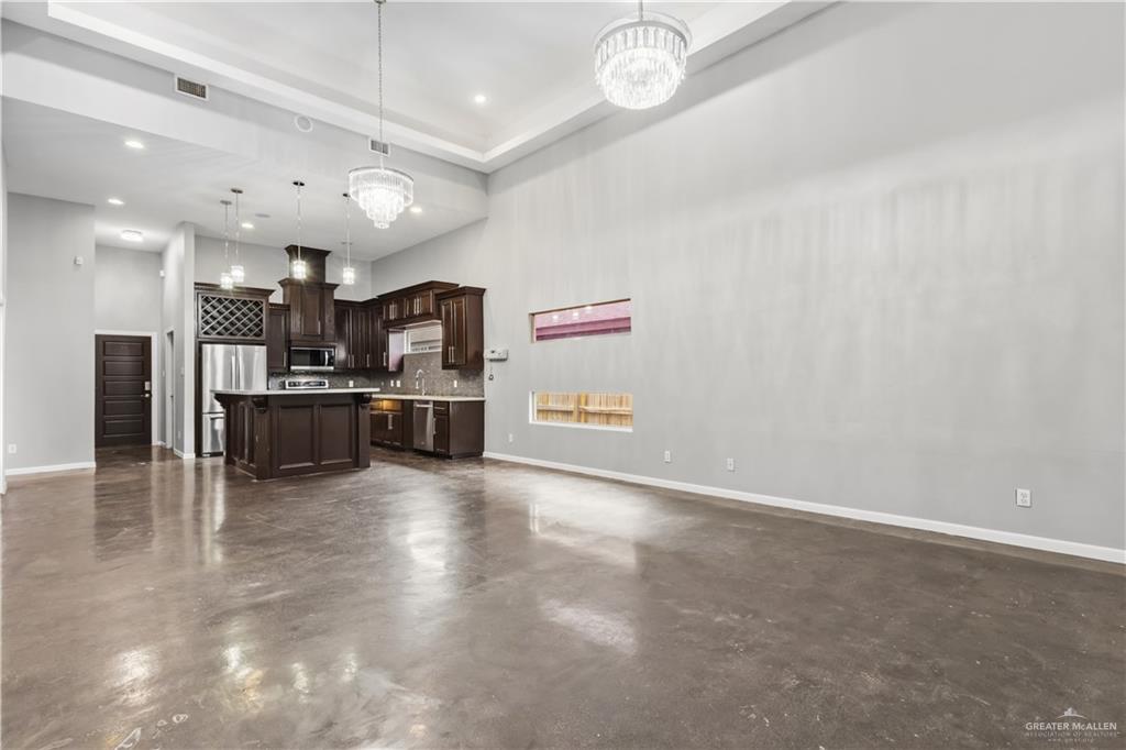 1342 Patsy Cline Drive Edinburg, TX 78541 - Photo 4 of 18 an empty room with kitchen view and a flat screen tv