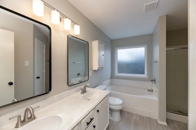 a bathroom with a toilet a bath tub a sink and mirror