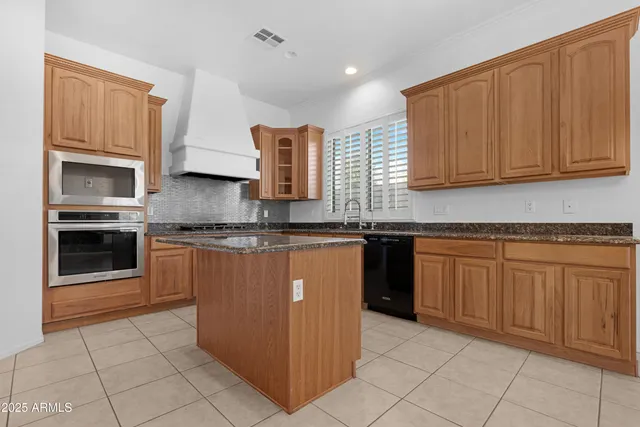 a large kitchen with stainless steel appliances granite countertop a sink and cabinets