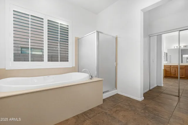 a bathroom with a tub sink and mirror