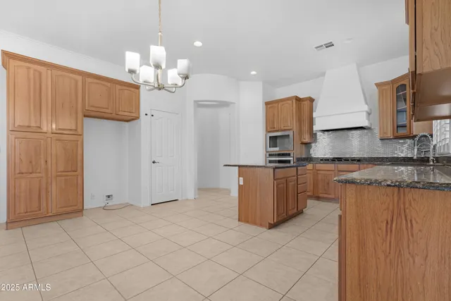 a kitchen with stainless steel appliances granite countertop a sink and a refrigerator