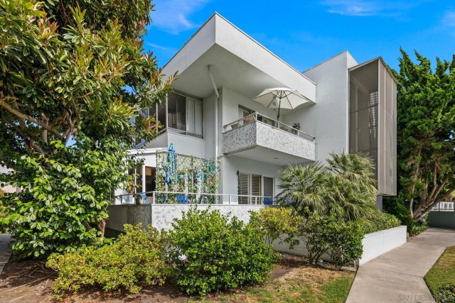 a front view of a house with plants and entryway