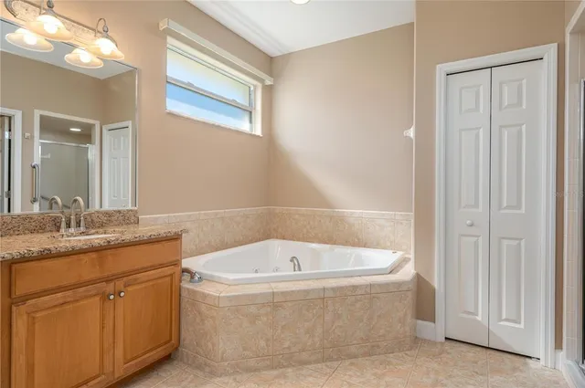 a bathroom with a granite countertop bathtub sink and mirror
