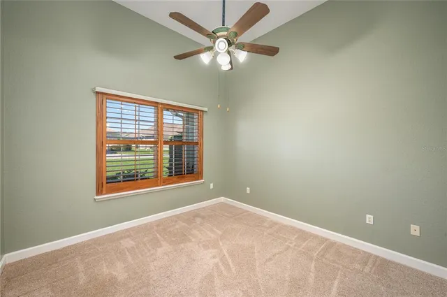 an empty room with a window and a fan
