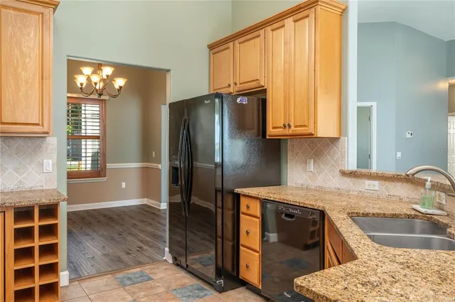 a kitchen with granite countertop a sink stainless steel appliances and cabinets
