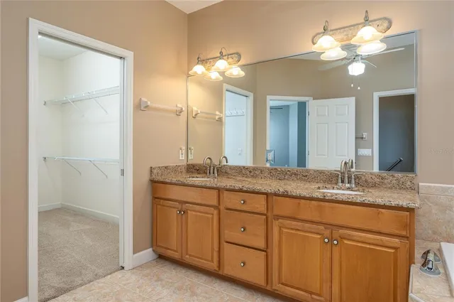 a bathroom with a granite countertop double vanity sink and a mirror