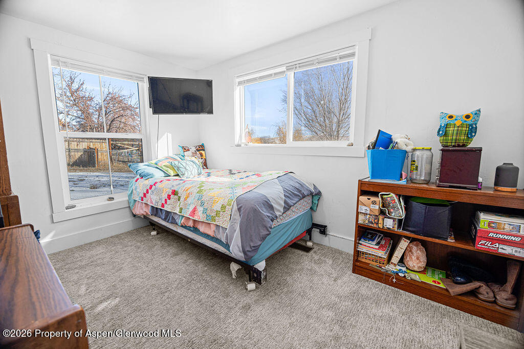 1464 Sage Street Craig, CO 81625 - Photo 27 of 47 a bedroom with a bed a dresser and a book shelf