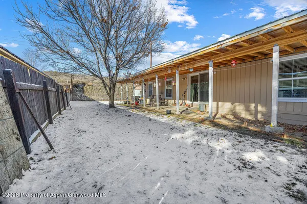 a backyard of a house with table and chairs