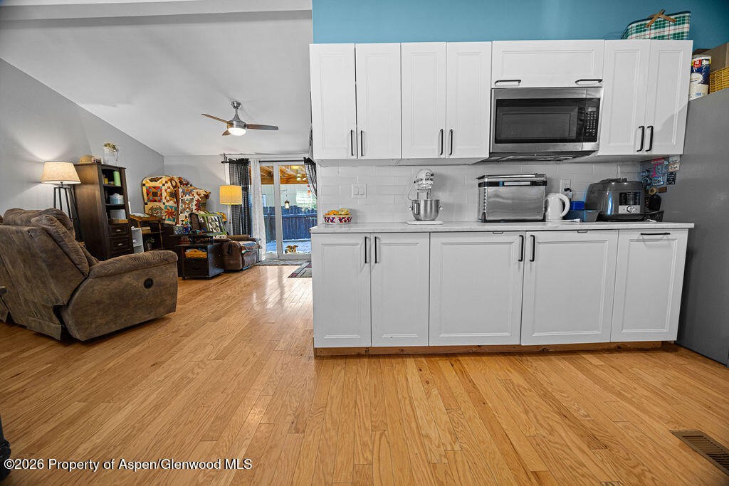 1464 Sage Street Craig, CO 81625 - Photo 5 of 47 a kitchen with stainless steel appliances granite countertop a stove top oven a sink dishwasher and a microwave with wooden floor