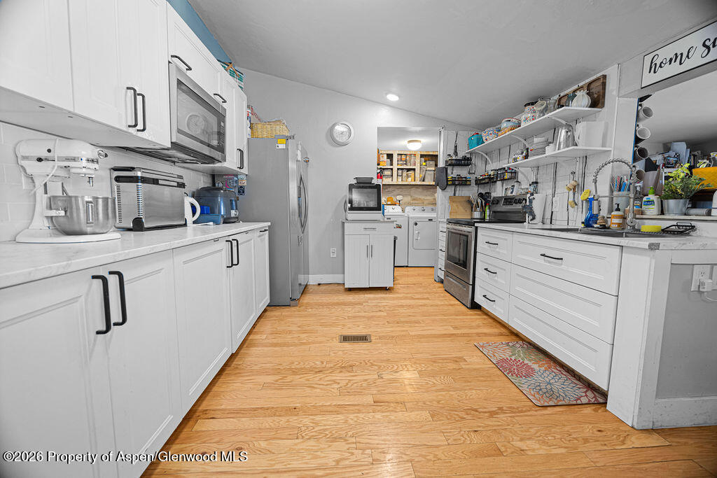 1464 Sage Street Craig, CO 81625 - Photo 7 of 47 a kitchen with stainless steel appliances granite countertop a sink and cabinets