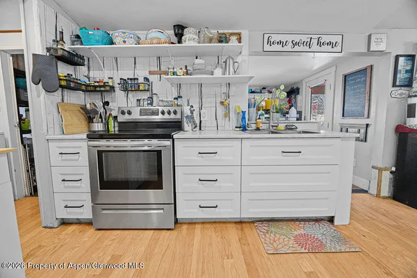 a kitchen with stainless steel appliances granite countertop a stove and cabinets