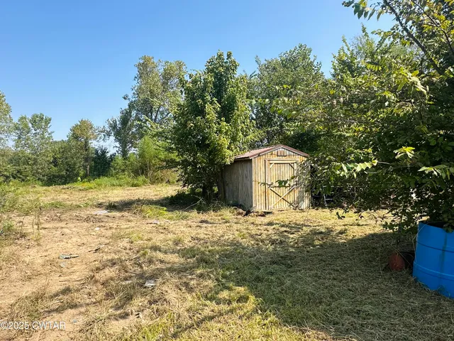 a view of a yard with large trees