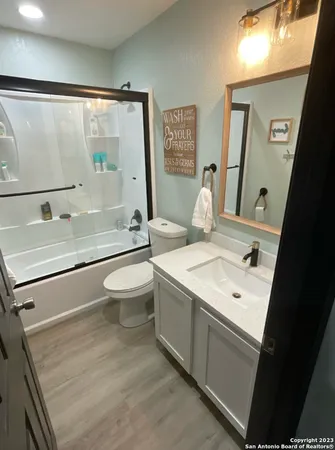 a bathroom with a sink a toilet and a large mirror