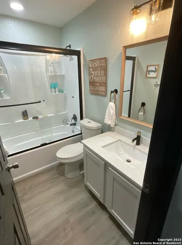 a bathroom with a sink a toilet and a large mirror