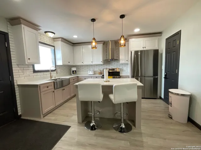 a kitchen with a sink appliances and cabinets