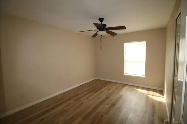 a view of empty room with wooden floor