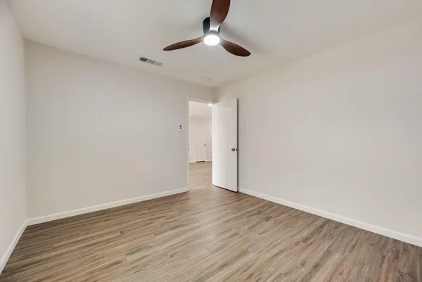 a view of an empty room with wooden floor