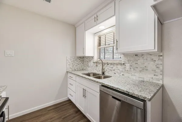 a kitchen with granite countertop cabinets sink and window