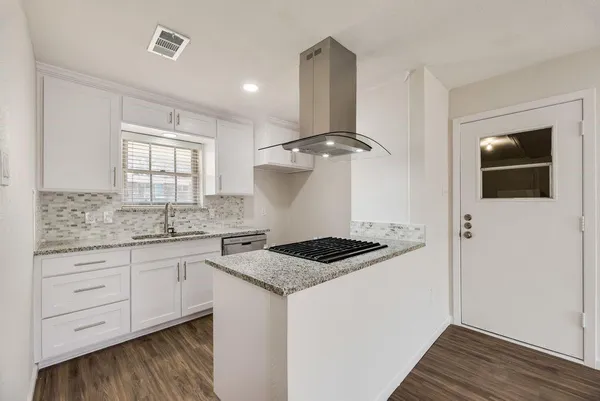 a kitchen with granite countertop a sink stove and cabinets
