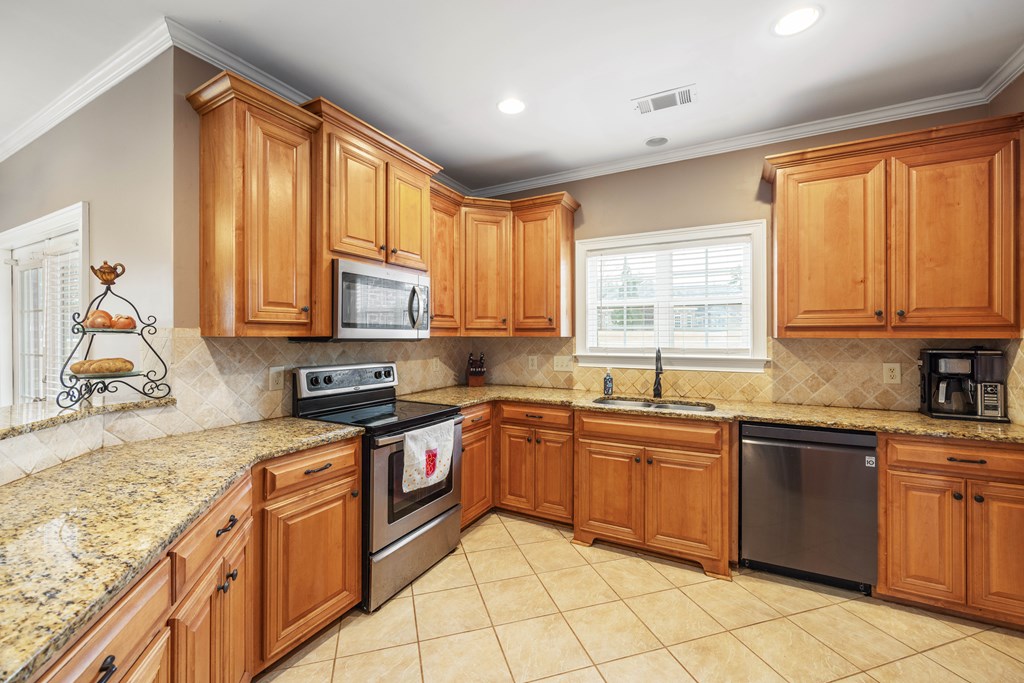 235 Voorhees Road Hamilton, GA 31811 - Photo 15 of 36 a kitchen with stainless steel appliances granite countertop stove top oven sink and cabinets