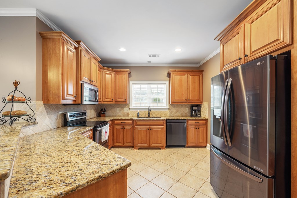 235 Voorhees Road Hamilton, GA 31811 - Photo 16 of 36 a kitchen with granite countertop stainless steel appliances a refrigerator stove top oven and sink