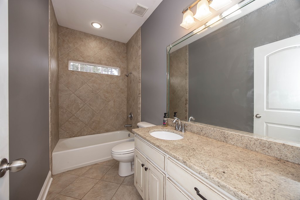 235 Voorhees Road Hamilton, GA 31811 - Photo 31 of 36 a bathroom with a granite countertop sink a toilet and shower