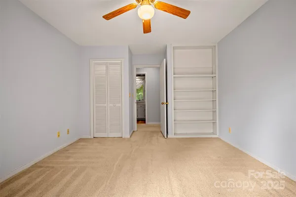 an empty room with closet and ceiling fan
