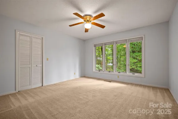 a view of a livingroom with a ceiling fan and window