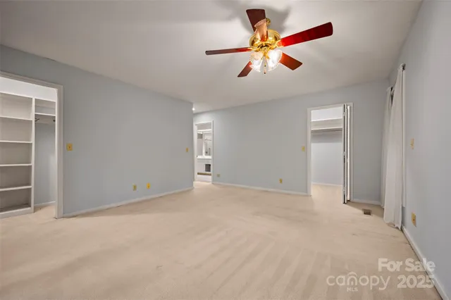 an empty room with closet and fan