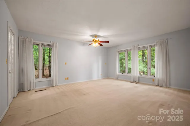 a view of a livingroom with a ceiling fan and window