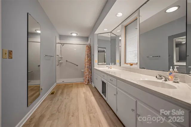 a spacious bathroom with a double vanity sink and mirror