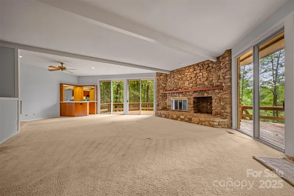 a view of an empty room with a fireplace and a window