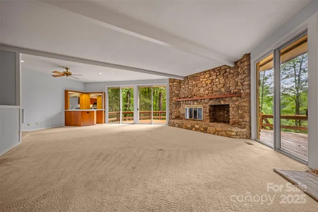 a view of an empty room with a fireplace and a window